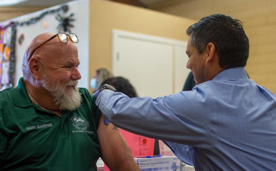 Congressman Raul Ruiz, a medical doctor, administers a vaccine to  Desert Hot Springs Councilmember Gary Gardner at the  senior center in Desert Hot Springs, Calif, on Oct. 28, 2022.