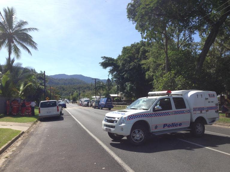 Police cordon off a street at the scene where eight children ranging from babies to teenagers were found dead in a house in the northern Australian city of Cairns on December 19, 2014