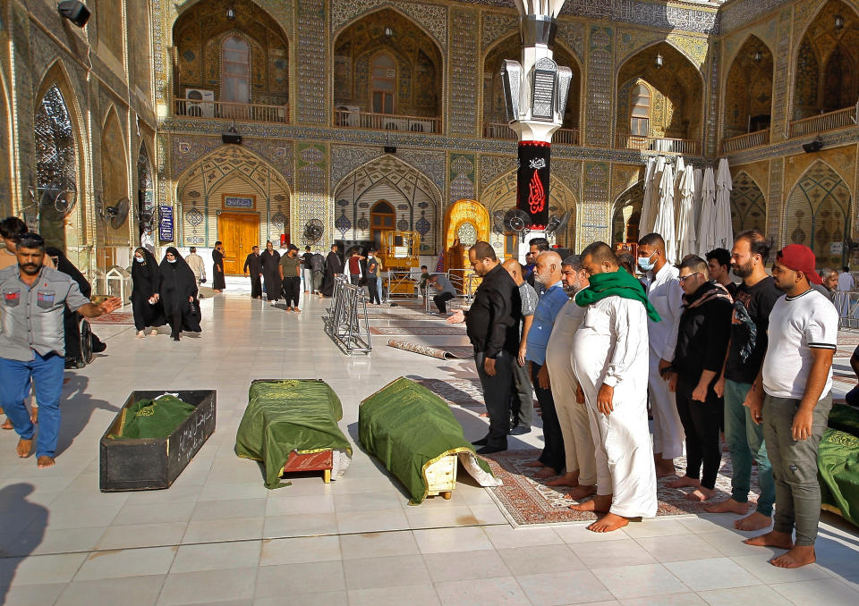 Mourners prepare to bury victims of a Monday bombing at a Baghdad market that was busy with shoppers a day before the Muslim Eid al-Adha holiday, in Najaf, Iraq, Tuesday, July 20, 2021. ​Iraqi medical officials said the Monday bomb attack in Sadr City, a Baghdad suburb, killed at least 30 people and wounded dozens of others. (AP Photo/Anmar Khalil)