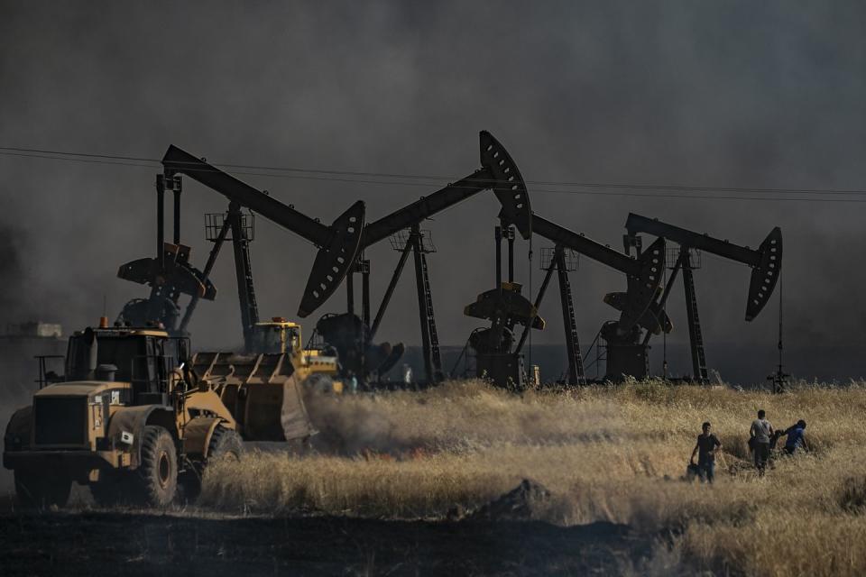 topshot   people battle a blaze next to an oil well in an agricultural field in the town of al qahtaniyah, in the hasakeh province near the syrian turkish border on june 10, 2019   fires have erupted in various parts of syria in recent weeks, with all sides blaming each other for starting themin the kurdish run breadbasket province of hasakeh, of which al qahtaniya is part, is has claimed several arson attacks on wheat fields photo by delil souleiman  afp        photo credit should read delil souleimanafp via getty images