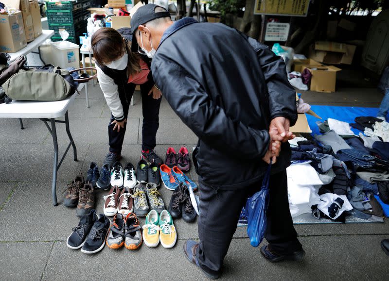 A volunteer takes part in shoes and clothes aid handouts for the needy, as the spread of the coronavirus disease (COVID-19) continues in Tokyo