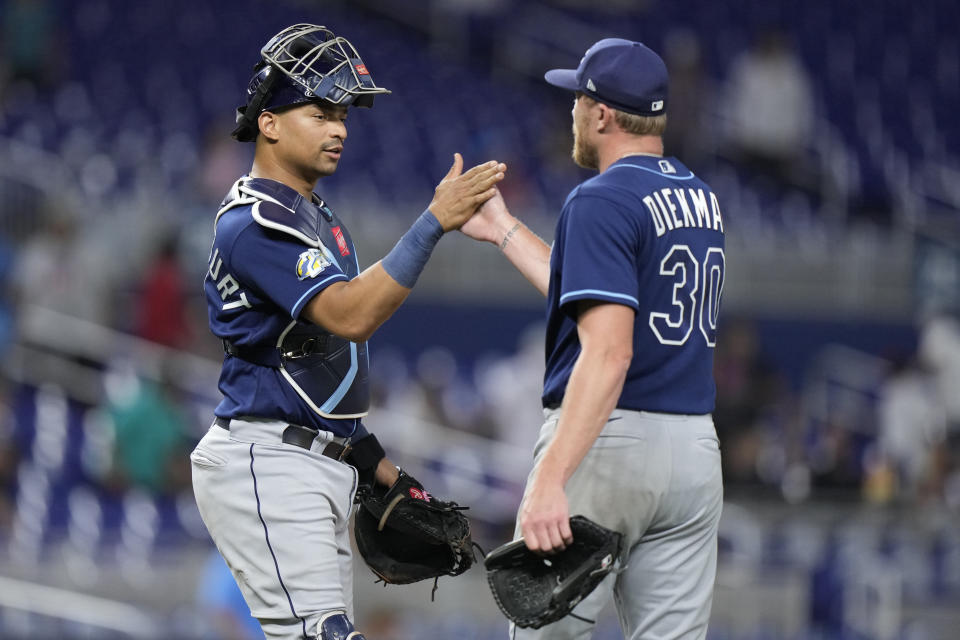 Tampa Bay Rays catcher Christian Bethancourt, left, and relief pitcher Jake Diekman (30) congratulate each other after the Rays beat the Miami Marlins 11-2 during a baseball game, Tuesday, Aug. 29, 2023, in Miami. (AP Photo/Wilfredo Lee)