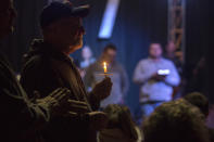 <p>Stan Collins of Benton, second from left, holds a candle during a vigil at Impact Church in Benton, Ky., Jan. 23, 2018. The vigil was held for victims of the Marshall County High School shooting earlier in the day. (Photo: Ryan Hermens/The Paducah Sun via AP) </p>