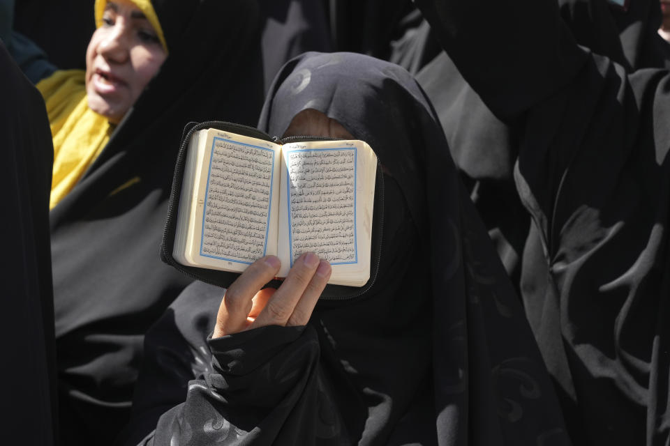 An Iranian demonstrator holds up a copy of Quran, Islam's holy book, during a protest of the burning of a Quran in Sweden, in front of the Swedish Embassy in Tehran, Iran, Friday, June 30, 2023. On Wednesday, a man who identified himself in Swedish media as a refugee from Iraq burned a Quran outside a mosque in central Stockholm. (AP Photo/Vahid Salemi)