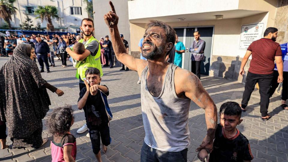 PHOTO: A Palestinian man with a child reacts outside Shifa hospital in Gaza City on Oct. 12, 2023 as raging battles between Israel and the Hamas movement continue for the sixth consecutive day. (Mahmud Hams/AFP via Getty Images)