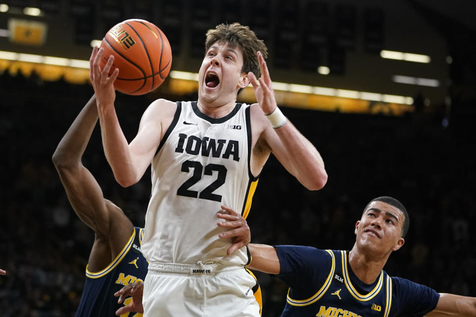 Iowa forward Patrick McCaffery (22) drives to the basket ahead of Michigan forward Caleb Houstan, right, during the second half of an NCAA college basketball game, Thursday, Feb. 17, 2022, in Iowa City, Iowa. (AP Photo/Charlie Neibergall)