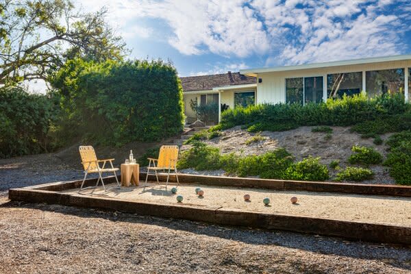 The couple kept the existing bocce court, and added throwback seating to match the midcentury mood.