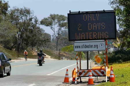 A road sign warns residents heading into Rancho Santa Fe, California of water restrictions for their yards due to the drought June 24, 2015. REUTERS/Mike Blake/File Photo