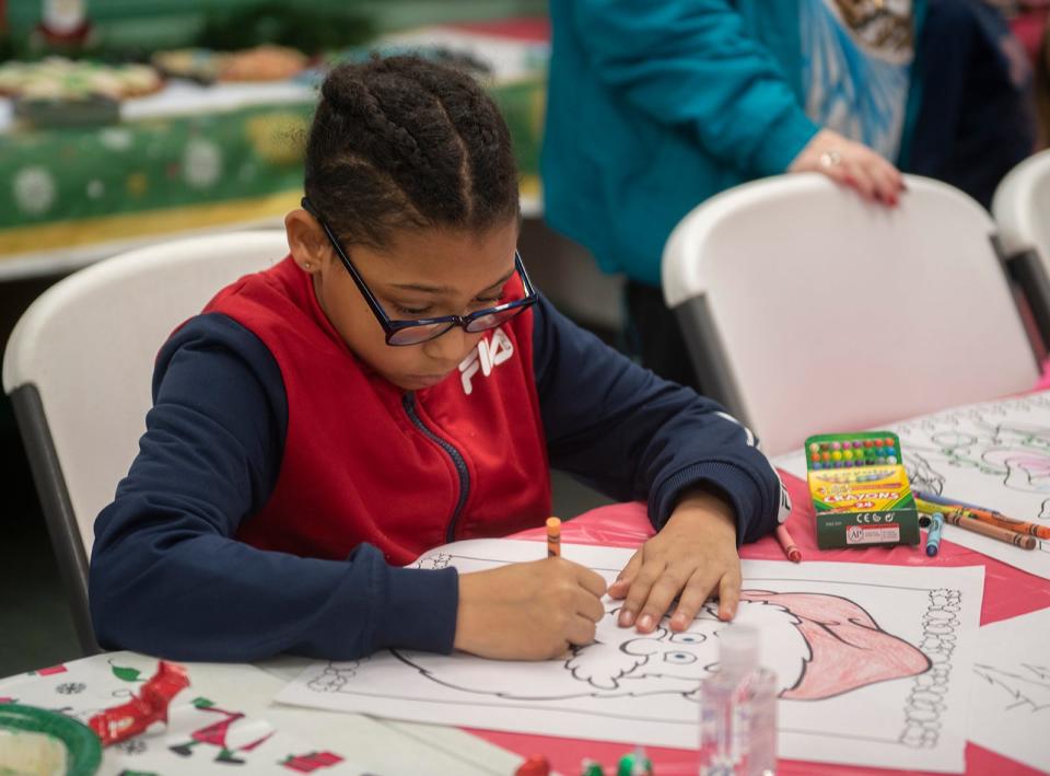 Kari Ware, 9, colors a Santa picture.