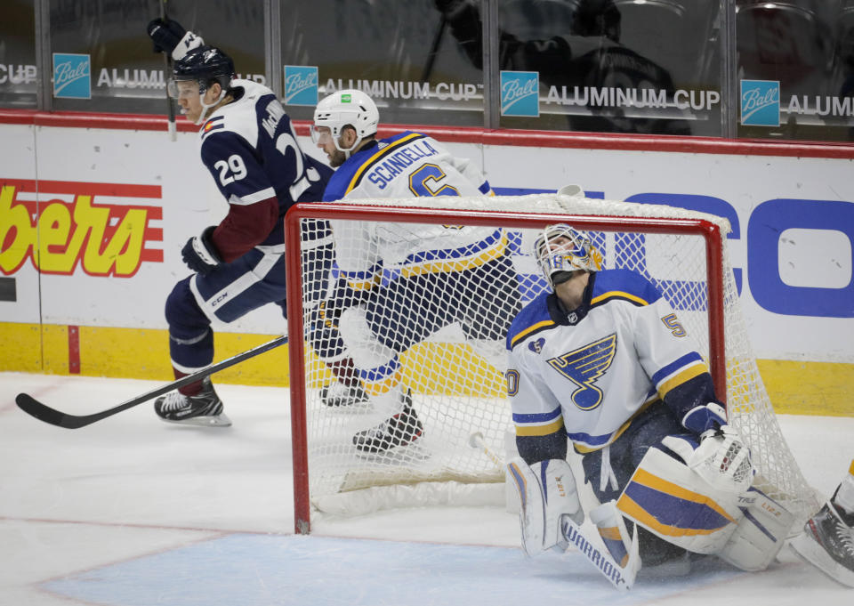 St. Louis Blues goaltender Jordan Binnington (50) reacts to a goal by Colorado Avalanche center Nathan MacKinnon (29) in the second period of an NHL hockey game in Denver, Friday, April 2, 2021. Blues defenseman Marco Scandella (6) skates behind the goal. (AP Photo/Joe Mahoney)