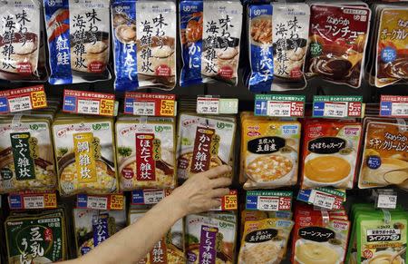 A staff arranges Kewpie Corp's nursing care food packages on a display shelf at an Ito-Yokado shopping centre in Tokyo August 5, 2014. REUTERS/Yuya Shino