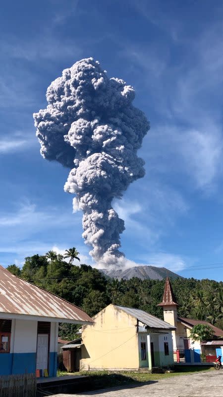 A column of ash rises over the Gunung Ibu volcano