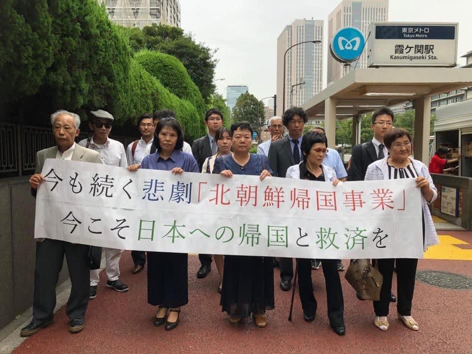 曾跟隨北韓歸國運動抵達北韓，而後棄朝脫北的5名脫北者，在2018年於日本法院對北韓提起訴訟。5名原告在支持者的陪同下拉起布條，上頭文字意為「現在仍在持續的悲劇『北韓歸國運動』，現在正是時候給他們救贖讓他們回日本」。在日朝鮮人大多是在二戰時期到日本工作，或是在韓戰偷渡來到日本的。   圖／Human Rights Watch