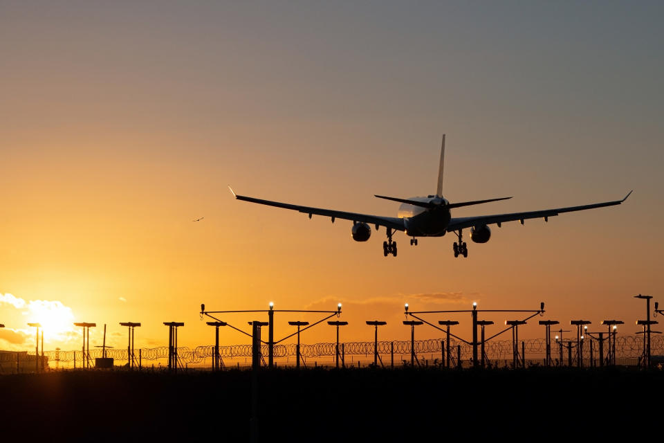 Airplane flying with a low sun in the sky