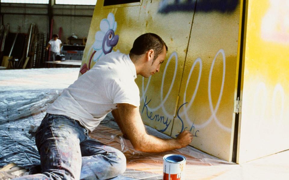 The artist Kenny Scharf signing his finished work, a swing ride dedicated to the ‘cosmic spirits of flight’