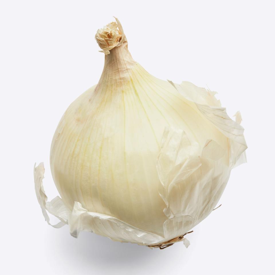 A white onion sheds its skin.