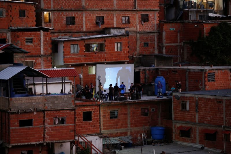 Members of Unloading zone NGO set a screen at the roof of a house in the low-income neighborhood of Petare, amid the coronavirus disease (COVID-19) outbreak in Caracas