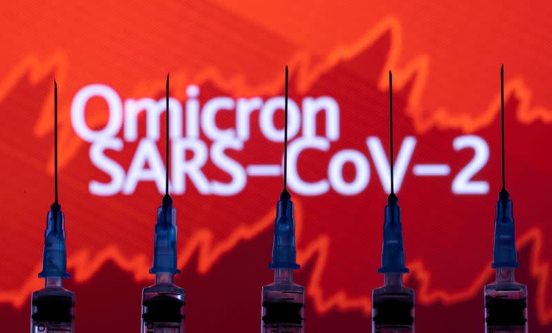 FILE PHOTO: Syringes with needles are seen in front of a displayed stock graph and words "Omicron SARS-CoV-2" in this illustration taken