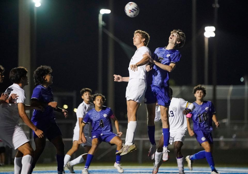 Naples Golden Eagles midfielder Cason Shepard (14) and Barron Collier Cougars defender Elijah Acker (5) battle for a corner kick during the first half of the Class 5A regional final at Barron Collier High School in Naples on Wednesday, Feb. 21, 2024.