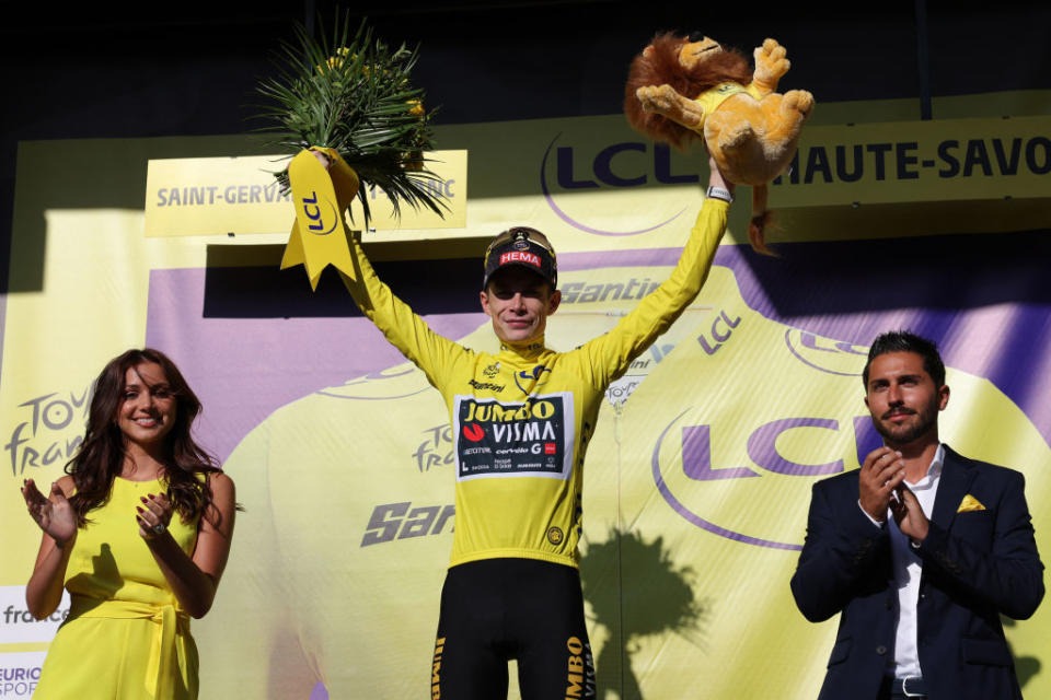 Jumbo-Visma's Danish rider Jonas Vingegaard (C) celebrates on the podium with the overall leader's yellow jersey after the 15th stage of the 110th edition of the Tour de France cycling race, 179 km between Les Gets Les Portes du Soleil and Saint-Gervais Mont-Blanc, in the French Alps, on July 16, 2023. (Photo by Thomas SAMSON / AFP)