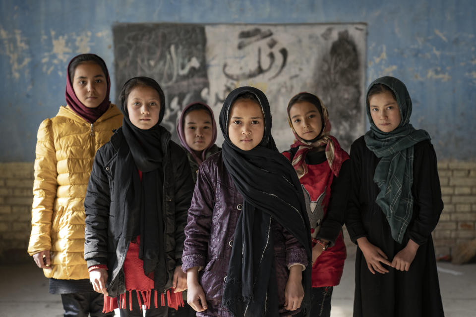 Afghan schoolgirls pose for a photo in a classroom in Kabul, Afghanistan, Thursday, Dec. 22, 2022. The country's Taliban rulers earlier this week ordered women nationwide to stop attending private and public universities effective immediately and until further notice. They have banned girls from middle school and high school, barred women from most fields of employment and ordered them to wear head-to-toe clothing in public. Women are also banned from parks and gyms.(AP Photo/Ebrahim Noroozi)