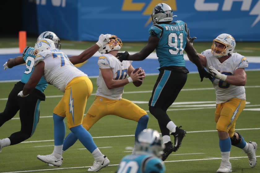 Inglewood, CA, Sunday, September 27, 2020 - Los Angeles Chargers quarterback Justin Herbert (10) is hit in the face by Carolina Panthers defensive end Yetur Gross-Matos (97) for a penalty as the Chargers drive for a late touchdown at SoFi Stadium. (Robert Gauthier/ Los Angeles Times)