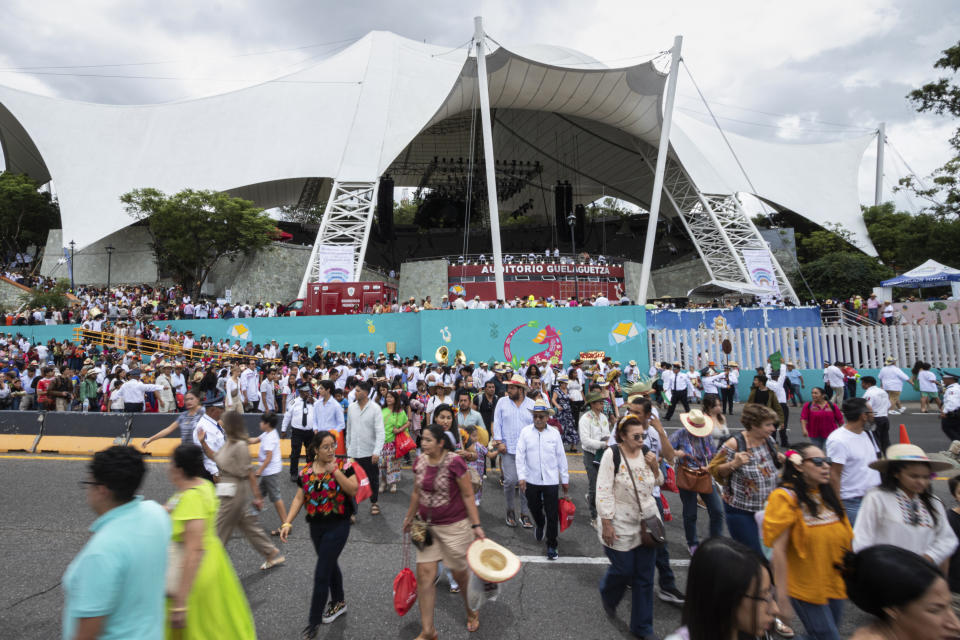 People leave the auditorium at the end of the first day of the Guelaguetza festival in Oaxaca City, Monday, July 17, 2023. During the government-sponsored event, 16 Indigenous ethnic groups and the Afro-Mexican community promote their traditions through public dances, parades and craft sales. (AP Photo/Maria Alferez)