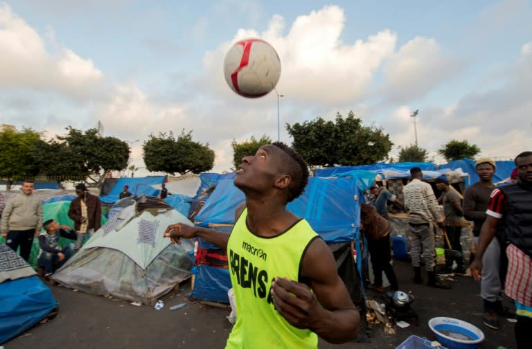 A sub-Saharan migrant practices his skills at a make-shift football pitch in the Oulad Ziane migrant camp in Morocco's Casablanca on February 19, 2018