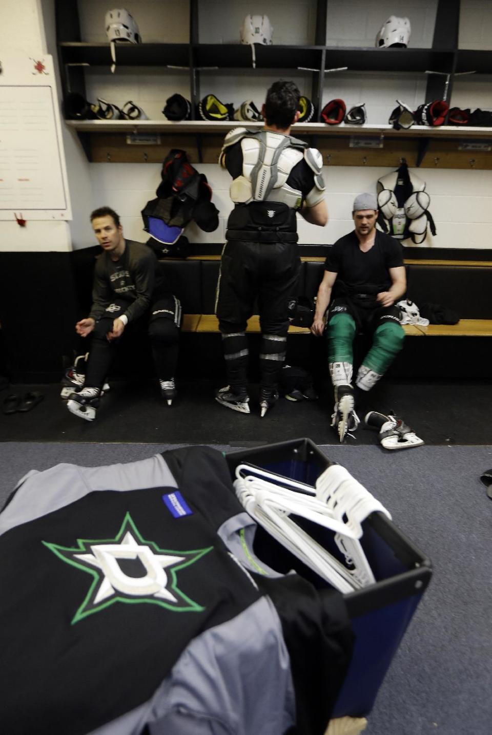 Dallas Stars' Ray Whitney, left, Shawn Horcoff, center, and Jamie Benn take off equipment following an NHL hockey practice Tuesday, March 11, 2014, in St. Louis. Dallas Stars' Rich Peverley is undergoing testing to determine what triggered his collapse during a game Monday night in Dallas. The Stars are scheduled to play the St. Louis Blues tonight in St. Louis. (AP Photo/Jeff Roberson)