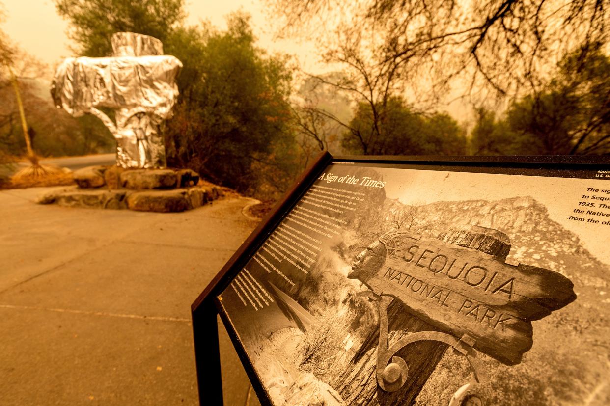 Fire-resistant wrap covers a historic welcome sign as the KNP Complex as fire burns in Sequoia National Park, California, on Wednesday (AP)