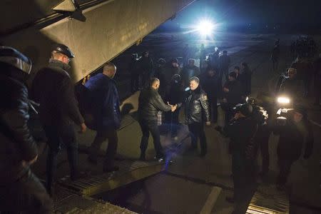 Ukraine's President Petro Poroshenko (C) shakes hands with a Ukrainian prisoner of war (POW) returning home after being exchanged for pro-Russian separatist prisoners, in Kiev December 27, 2014. REUTERS/Mikhail Palinchak/Ukrainian Presidential Press Service/Handout via Reuters