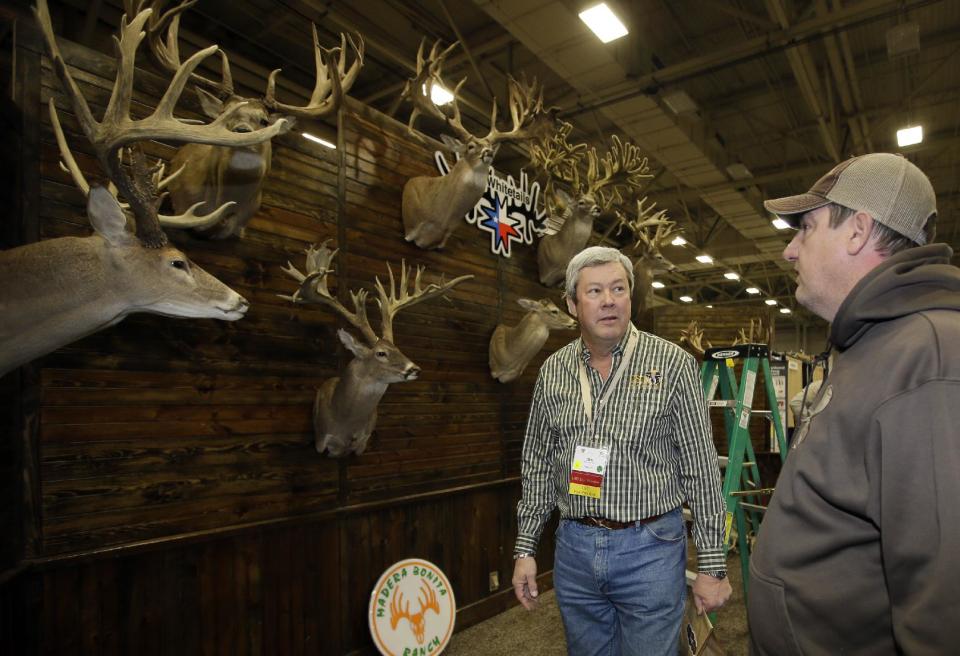 Ben Carter, director del Safari Club de Dallas (izquierda) habla con Mike Woods, del grupo 4JM White Tails Hunting, en un salón de exhibición de trofeos de caza, el miércoles 8 de enero de 2014, en Dallas. (Foto AP/Tony Gutiérrez)