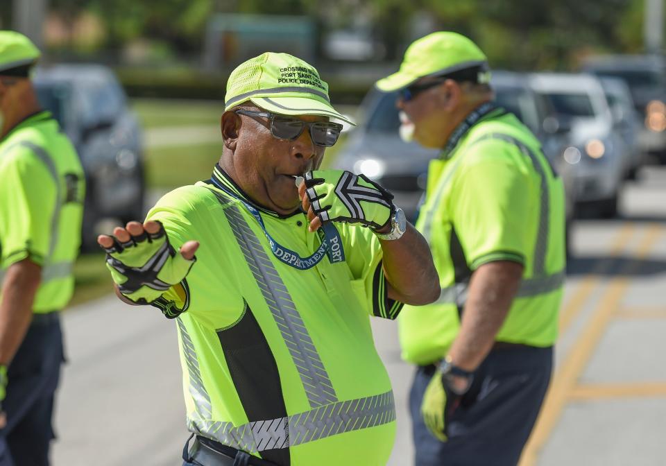 Port St. Lucie Police School Crossing Guard Venol Joseph keeps traffic stopped along Southeast Floresta Drive as other crossing guards play the part of students during their crossing guard's annual Traffic Certification Training at Floresta Elementary School on Friday, Aug. 5, 2022, in Port St. Lucie. "We have to have good training to keep the kids safe," Joseph said. "We don't want anyone to be hurt."