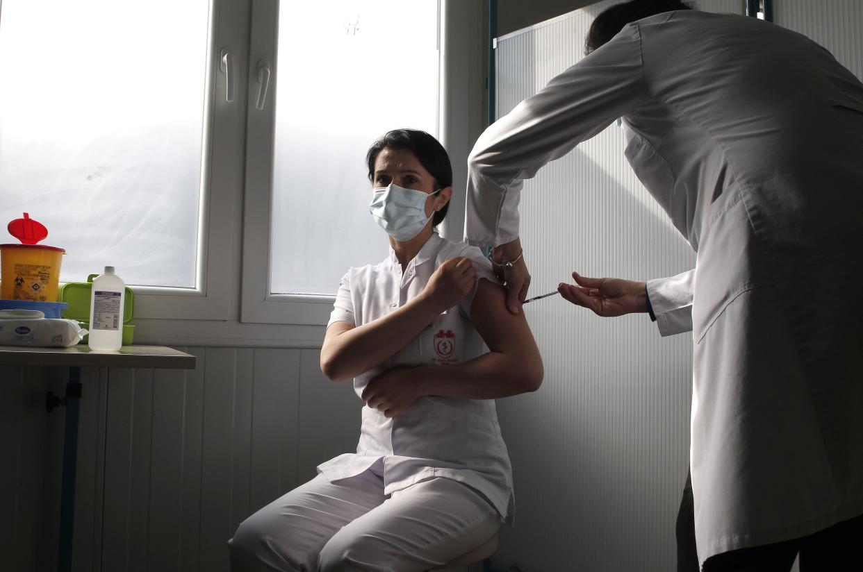 A health worker is administered the Pfizer-BioNTech COVID-19 vaccine on the first day of the vaccination campaign at the Clinique for Infectious Diseases in Skopje, North Macedonia on Wednesday, Feb. 17, 2021. North Macedonia began administering vaccinations against the coronavirus Wednesday from the first batch of 4,680 doses of Pfizer vaccines donated by neighboring Serbia over the weekend.