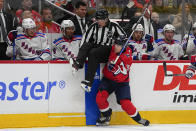 Washington Capitals right wing Nicolas Aube-Kubel (96) collides with linesman Steve Barton (59) during the third period of an NHL hockey game against the New York Rangers, Saturday, Feb. 25, 2023, in Washington. The Capitals won 6-3. (AP Photo/Julio Cortez)