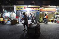 Pham Van Sang, a street food vendor who moved from the Mekong Delta, carries his cookware and other equipment to his apartment after wrapping up for the day in Ho Chi Minh City, Vietnam, Monday, Jan. 22, 2024. He sells noodles in the city's industrial zone, a popular destination for many migrants from the Mekong Delta seeking a better life as he did. (AP Photo/Jae C. Hong)