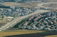 FILE - This Tuesday, July 29, 2003 file photo is an aerial view over West Bank showing a Palestinian village, left, and a Jewish settlement, right, separated by a wall, part of the separation fence Israel is building. Nine months of U.S.-driven diplomacy have left Israelis and Palestinians less hopeful than ever about a comprehensive peace agreement to end their century of conflict. Although a formula may yet be found to somehow prolong the talks past an end-of-April deadline, they are on the brink of collapse and the search is already on for new ideas. (AP Photo/Lefteris Pitarakis)