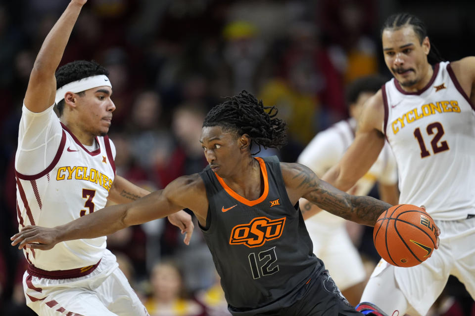 Oklahoma State guard Javon Small, center, drives between Iowa State guard Tamin Lipsey (3) and forward Robert Jones, right, during the second half of an NCAA college basketball game, Saturday, Jan. 13, 2024, in Ames, Iowa. Iowa State won 66-42. (AP Photo/Charlie Neibergall)