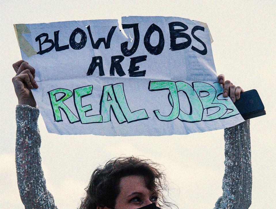 a demonstrator displays a placard reading blow jobs are real jobs during a protest in support of sex workers in berlin on 2 june 2021