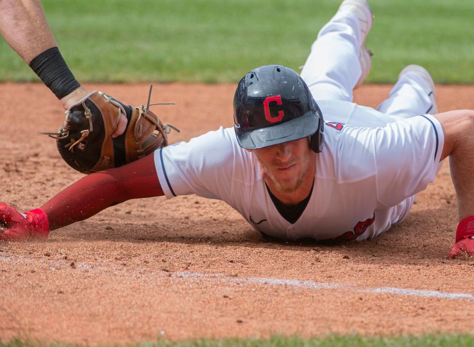 Cleveland's Myles Straw slides safely back to first base ahead of a tag by Chicago White Sox's Gavin Sheets during the third inning of a baseball game in Cleveland, Sunday, Sept. 26, 2021. (AP Photo/Phil Long)