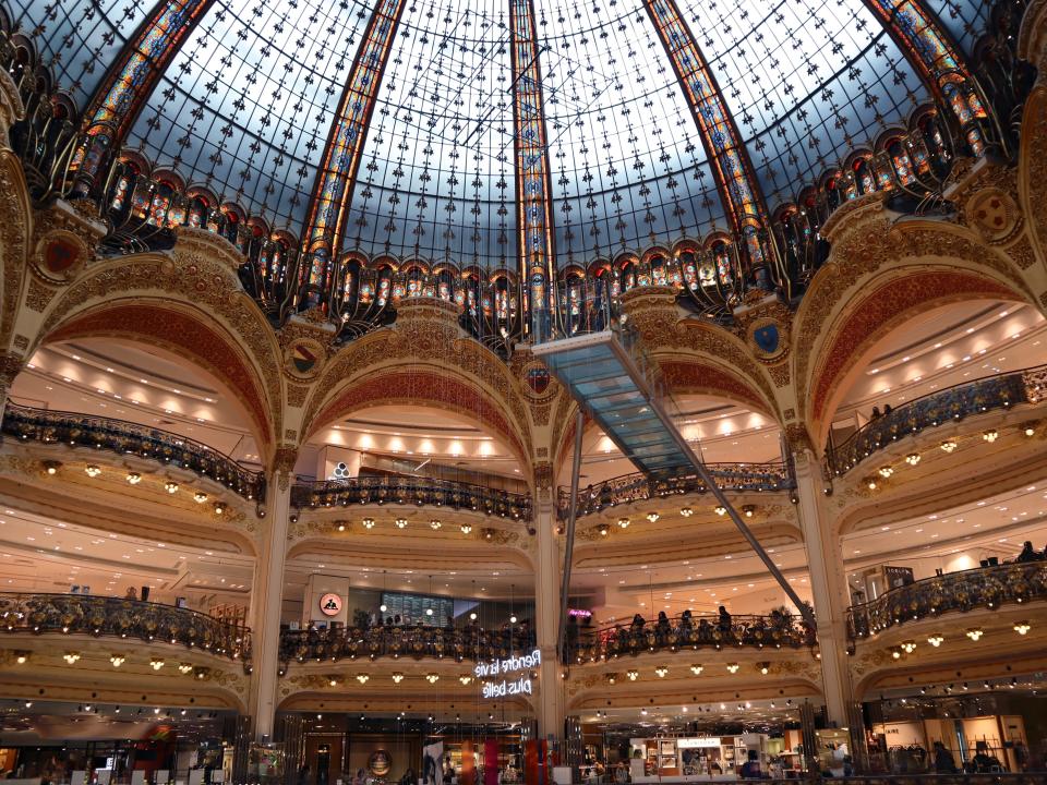 A dome-shaped glass roof with archways and balconies in fancy department store