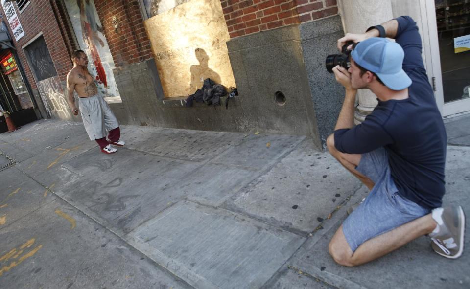 This Oct. 2, 2013 photo shows photographer Brandon Stanton, right, creator of the Humans of New York blog, as he takes a portrait of a dancing Luis Torres, 63, in the East Village in New York. Stanton’s magical blend of portraits and poignant, pithy storytelling has earned HONY more than 2 million followers online. Now he’s putting his work in a book, “Humans of New York,” due out Oct. 15 from St. Martin’s Press. (AP Photo/Kathy Willens)