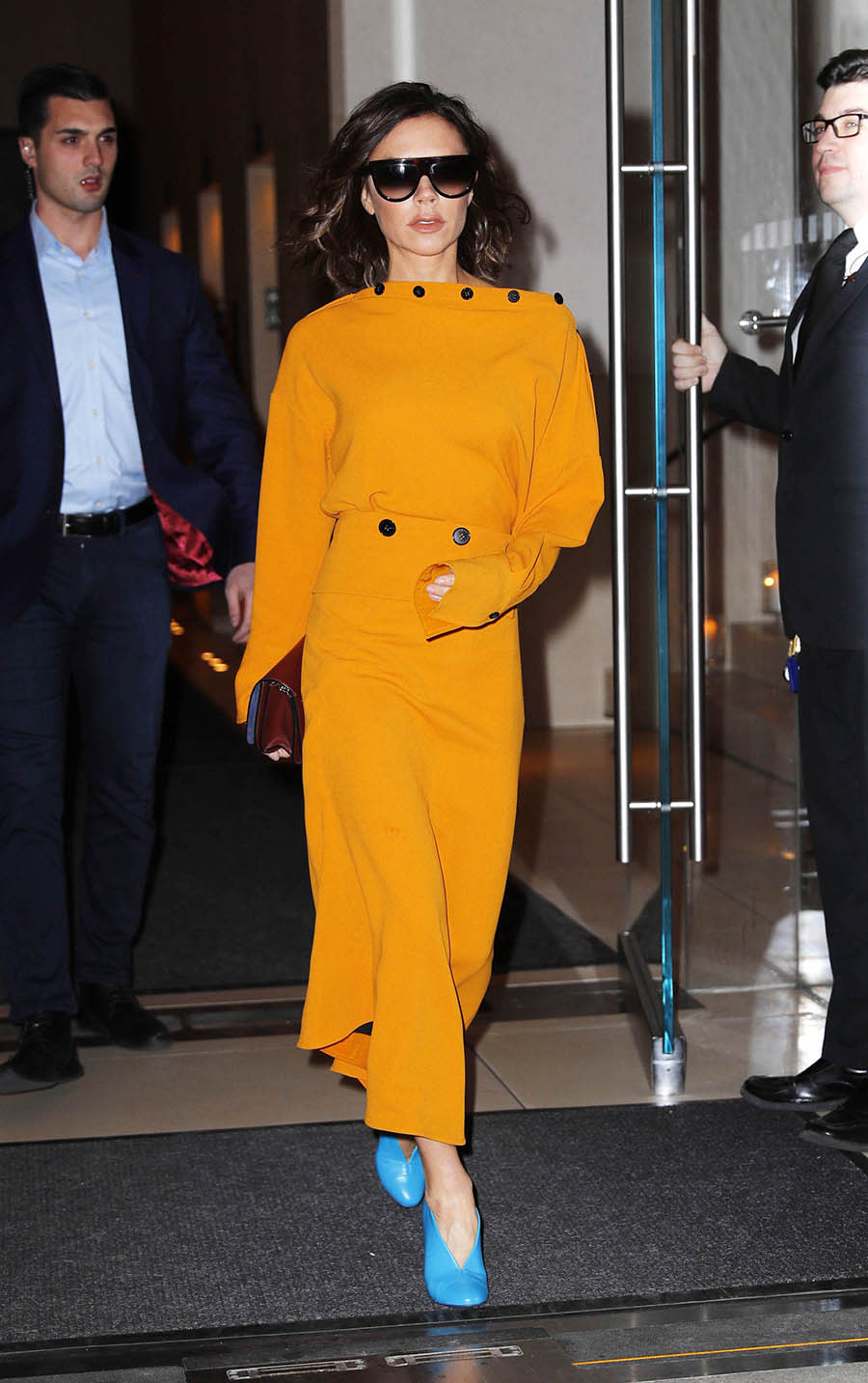 <p>Victoria Beckham paired an orange dress featuring button detailing with blue pumps in New York City. (Photo by XPX/Star Max/GC Images) </p>