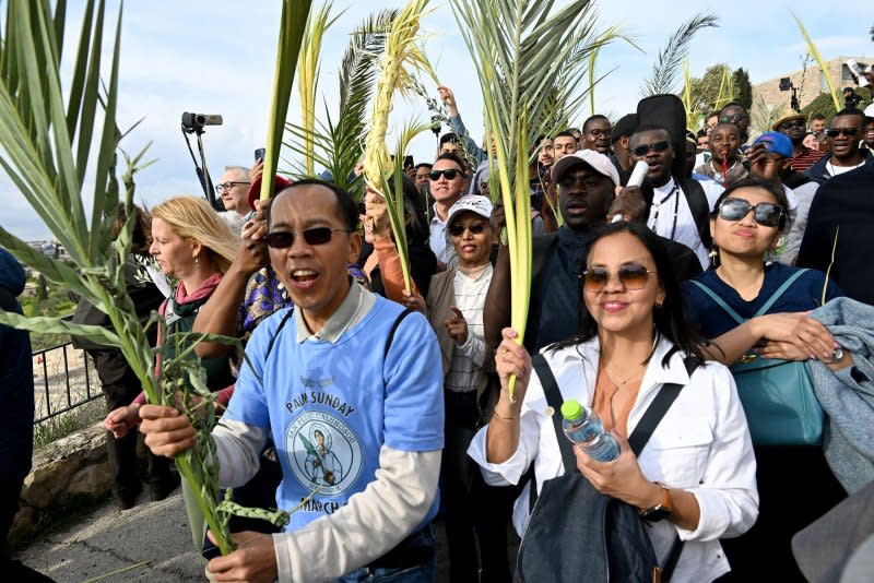 Christians wave olive and palm branches during the traditional Palm Sunday procession on the Mt. Of Olives, overlooking the Old City of Jerusalem, East Jerusalem, on Sunday, March 24, 2024. Photo by Debbie Hill/ UPI