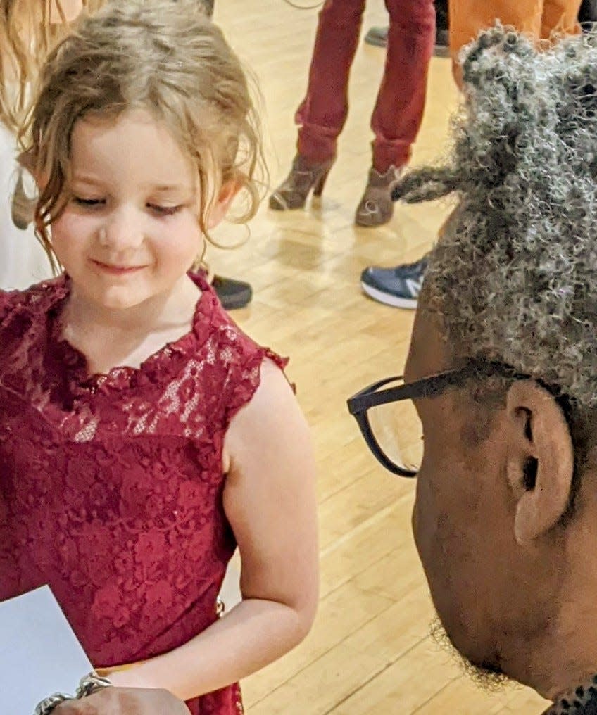 Five-year-old Patti Job meets artist Lonnie Holley.