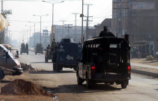 This file photo shows Pakistani soldiers and police patrolling a street in Bannu, in 2011. Nearly 400 prisoners including militants escaped from a jail in northwestern Pakistan after an attack by insurgents armed with guns, grenades and rockets