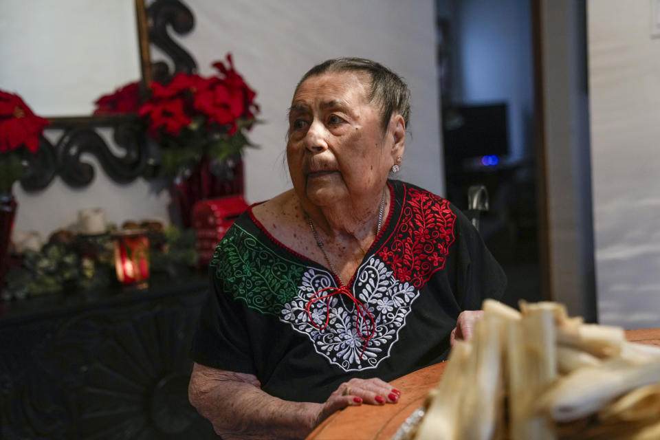 Aurora Sandoval waits for the next step in tamale-making with her family members at the family home Tuesday, Dec. 26, 2023, in Chicago. When she was 1, Noelia Sanchez and her mother Aurora, who had no work documents, were rounded up with dozens of other immigrants in a Texas town near the border. The U.S.-born child and her mother were forced to go to Mexico along with hundreds of thousands of other people. (AP Photo/Erin Hooley)