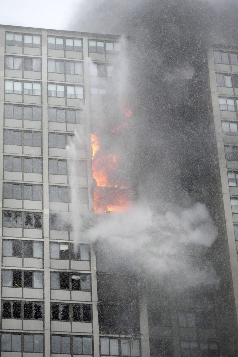 Flames leap skyward out of the Harper Square cooperative residential building in the Kenwood neighborhood of Chicago, Wednesday, Jan. 25, 2023. (AP Photo/Charles Rex Arbogast)