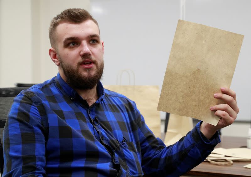 CEO of the "Re-leaf Paper" project Frechka shows a sheet of paper, made of fallen tree leaves, at the Zhytomyr Cardboard Factory in Zhytomyr