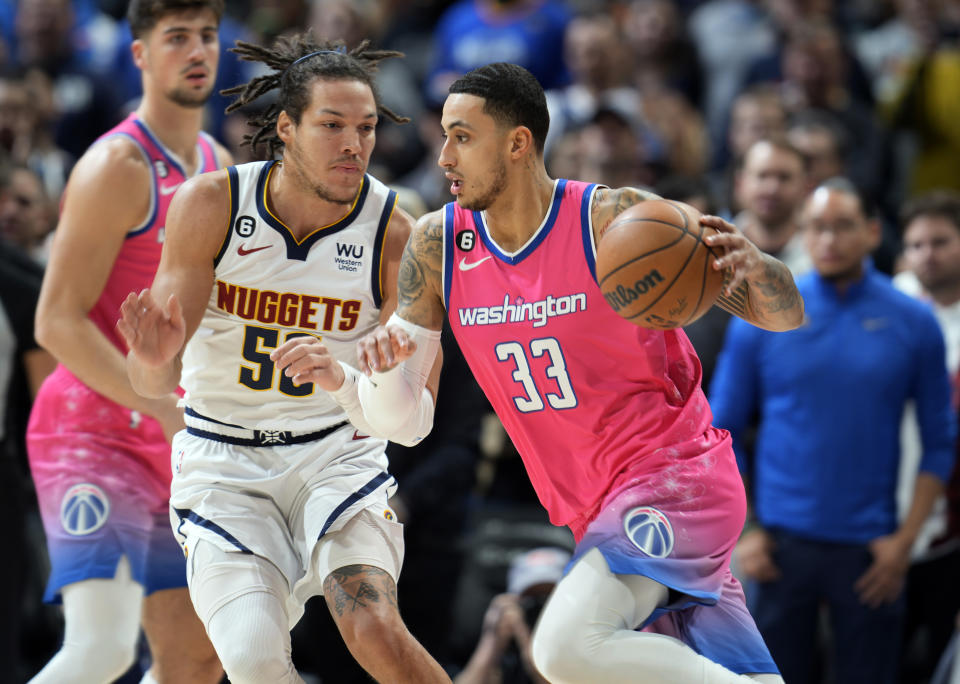 Washington Wizards forward Kyle Kuzma, right, drives the lane as Denver Nuggets forward Aaron Gordon defends in the first half of an NBA basketball game Wednesday, Dec. 14, 2022, in Denver. (AP Photo/David Zalubowski)